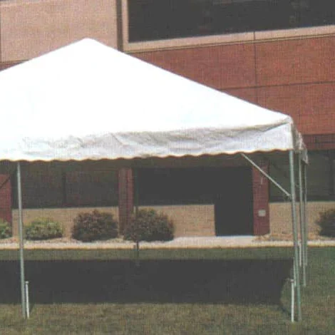 a0001118 White canopy tent on grass in front of brick building.