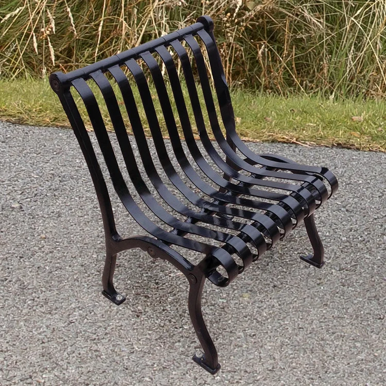 ivch-woarms-scene-black-1 Black metal park bench on paved surface.