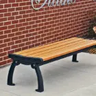 Outdoor bench against brick wall.