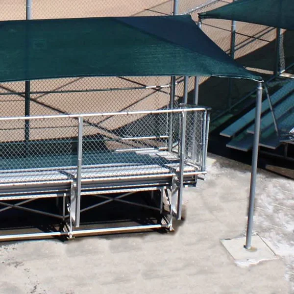 Outdoor bleachers with green canopies and metal railings.