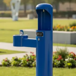 Blue drinking fountain in a park setting.