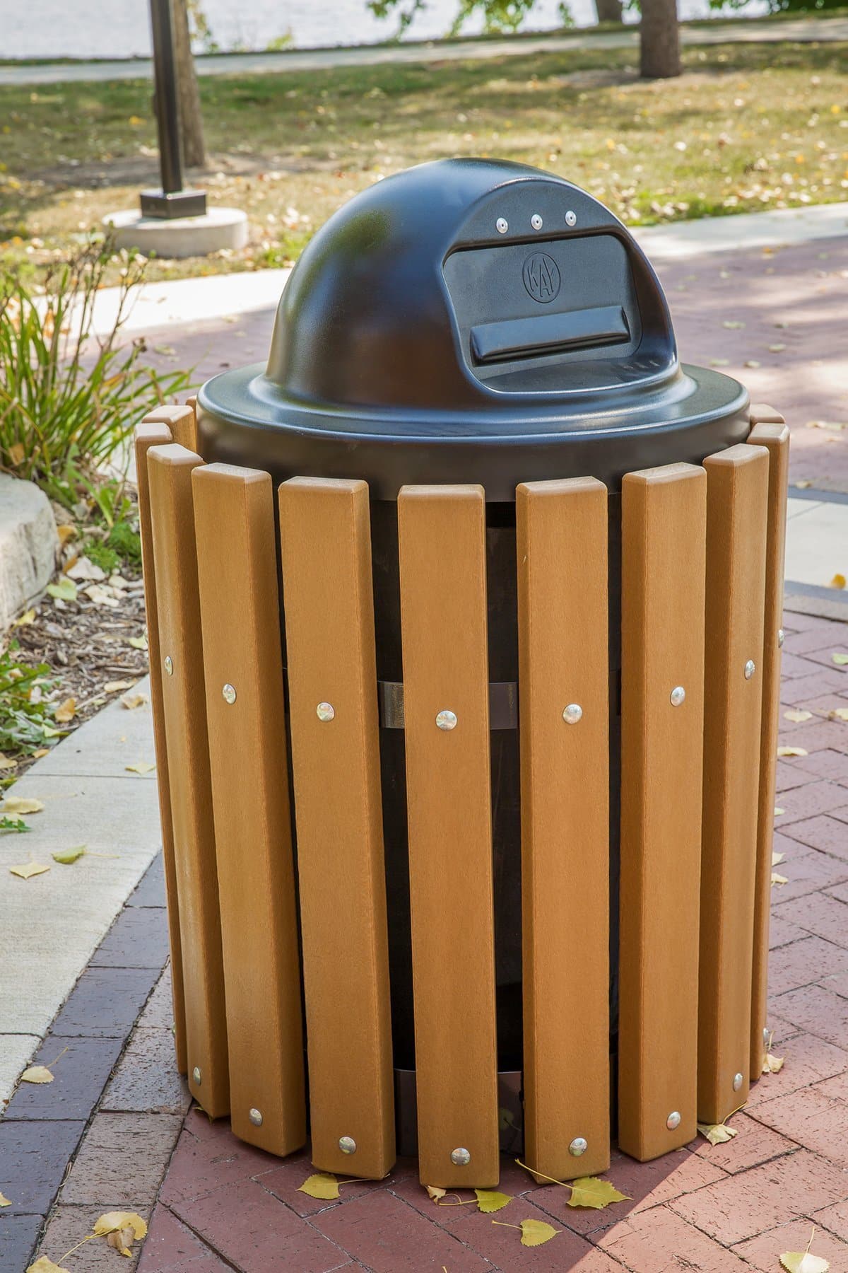 Outdoor trash can on a brick sidewalk.