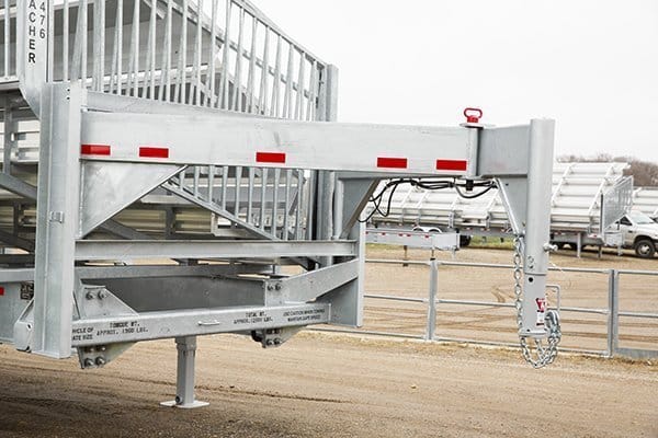 Metal cattle chute with red and white stripes.