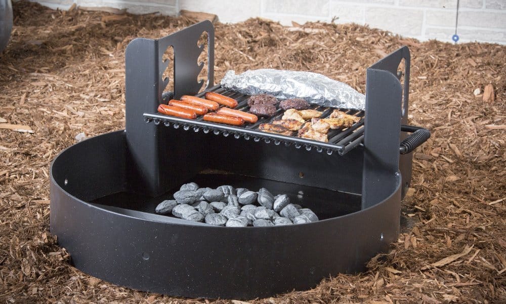 Outdoor grill cooking hot dogs and burgers over charcoal.