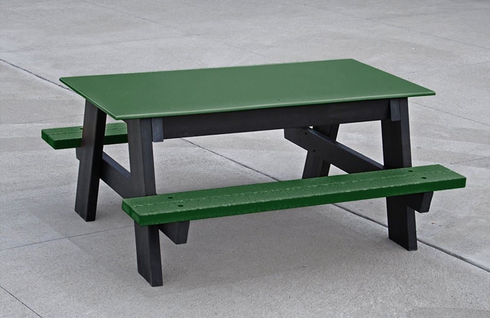 Green and black picnic table on a concrete surface.