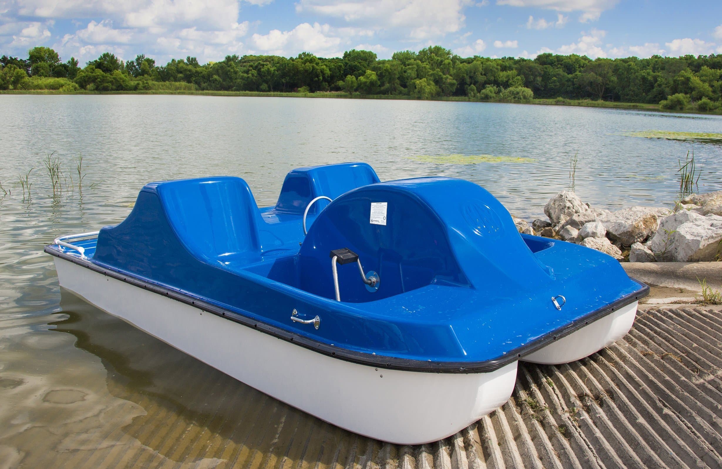 Pedal boat on a dock by a lake.