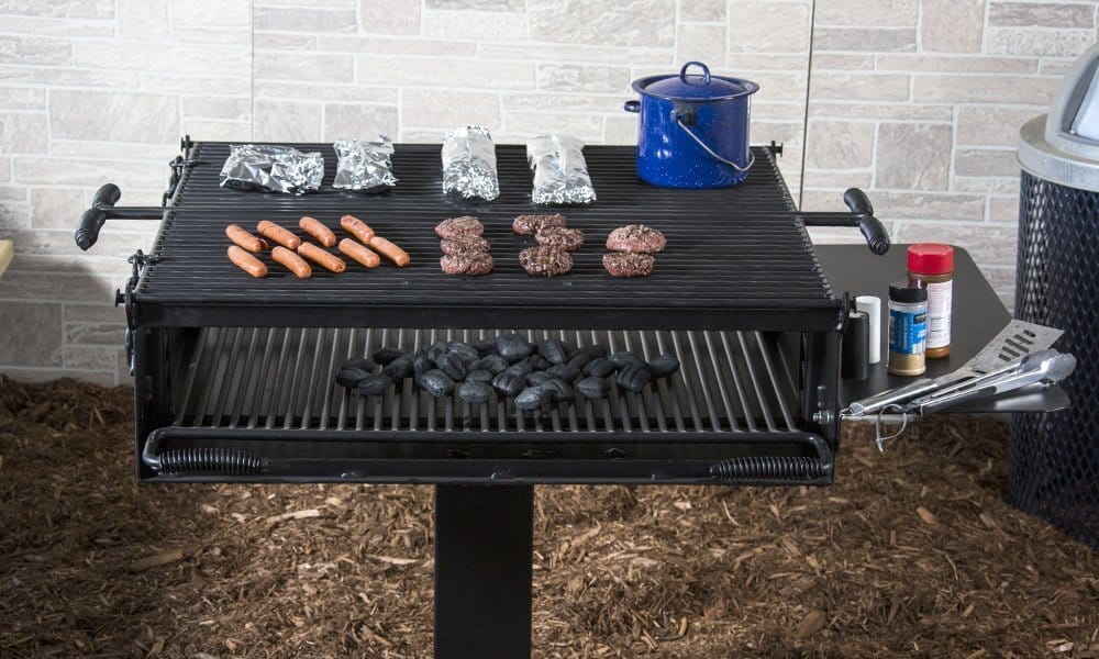 Outdoor grill setup with hot dogs, burgers, and charcoal.