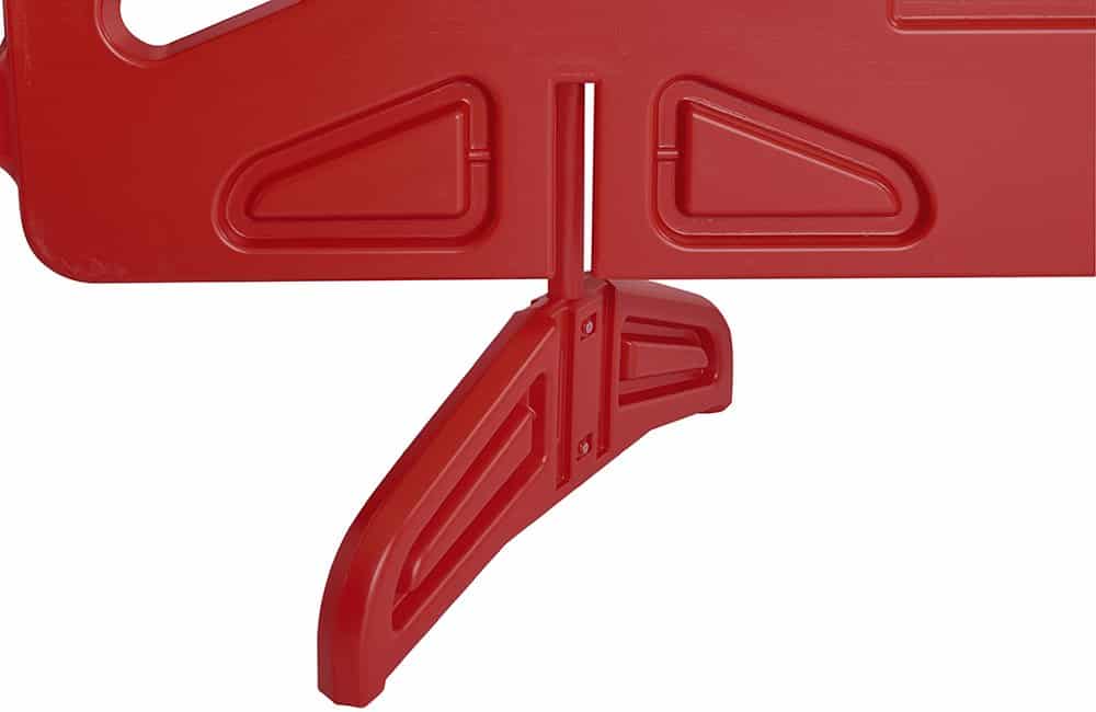 Red plastic object with a handle and cut-out shapes.