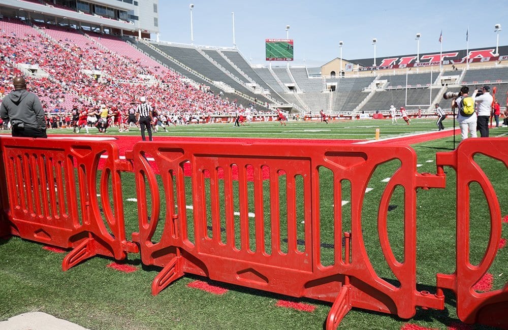 Red plastic barriers on a football field.