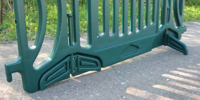 Green plastic barrier on paved surface.
