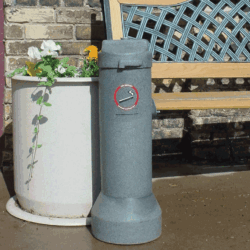 Cigarette ashtray on a patio next to a planter.