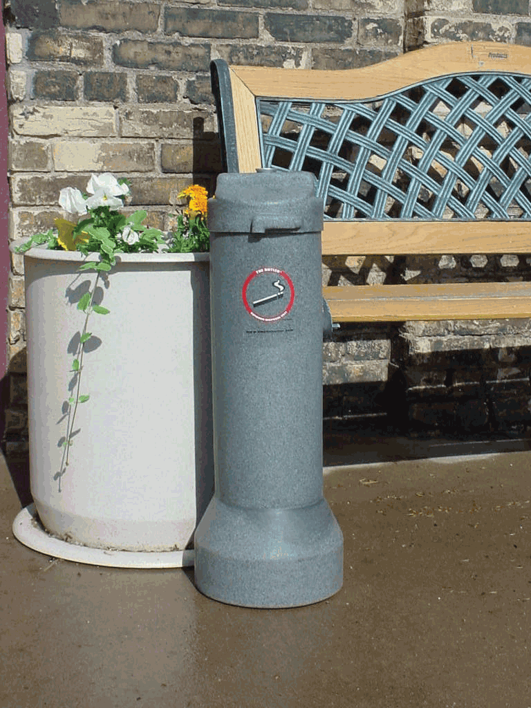 Cigarette ashtray on a patio next to a planter.