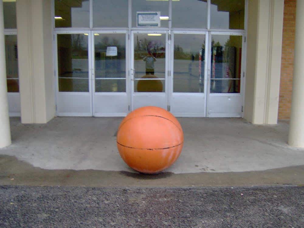 Large orange ball in front of a building.