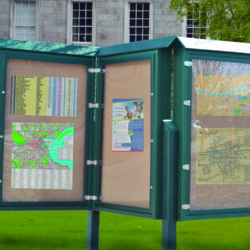 Outdoor information kiosk displaying maps and schedules.