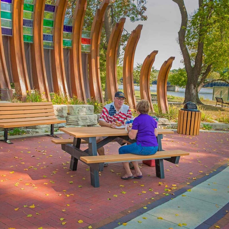 People sitting at a picnic table in a park.