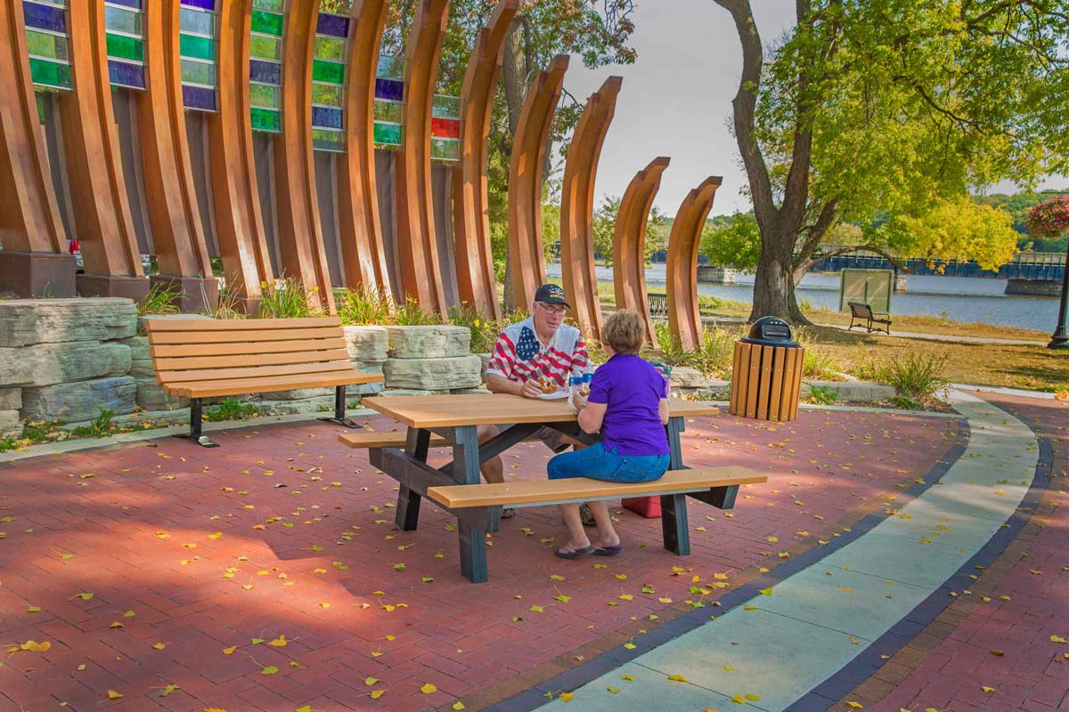 People sitting at a picnic table in a park.