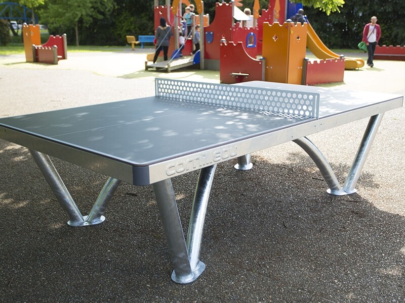 Outdoor ping pong table in a park setting.
