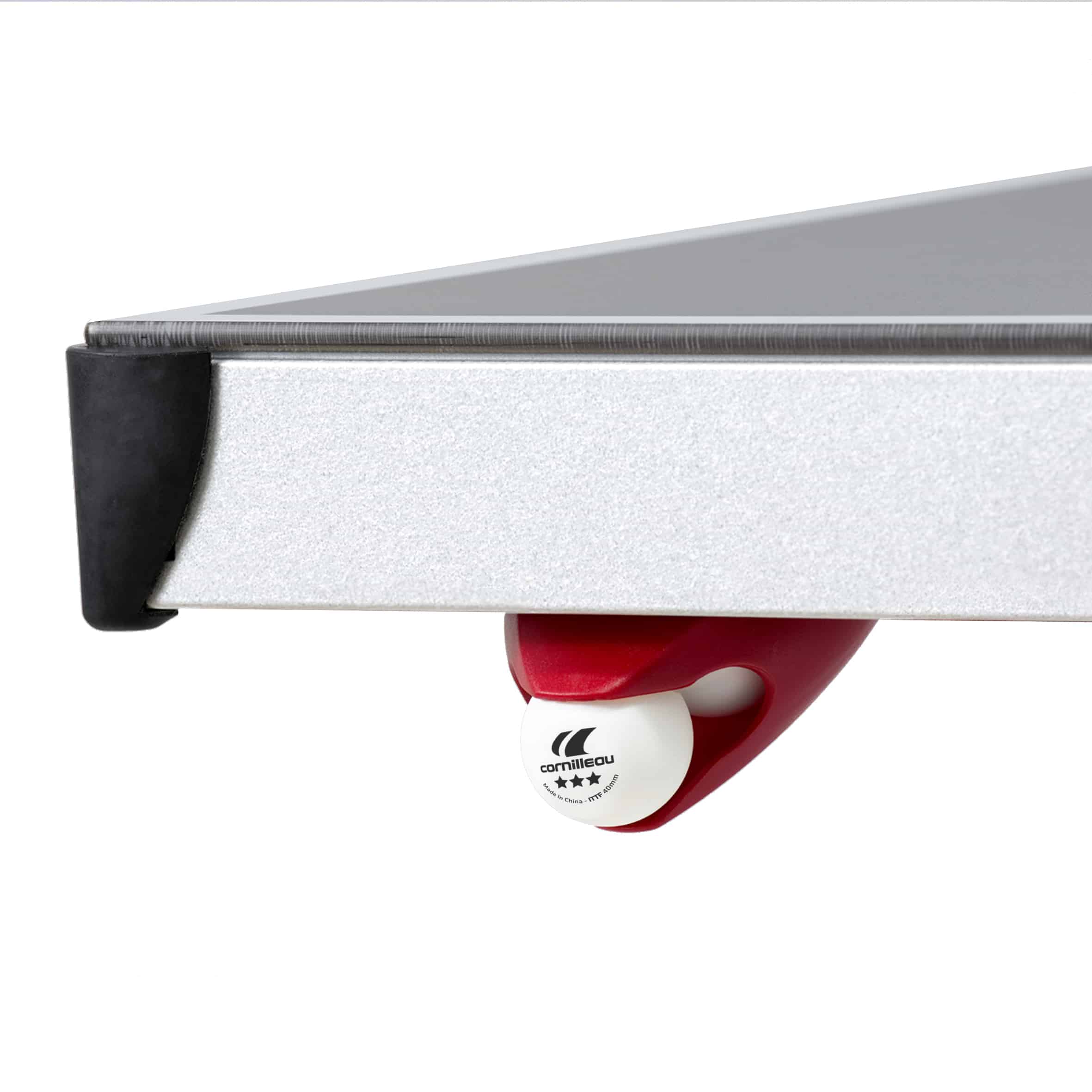 Close-up of a red ping pong ball dispenser on a white table tennis table.