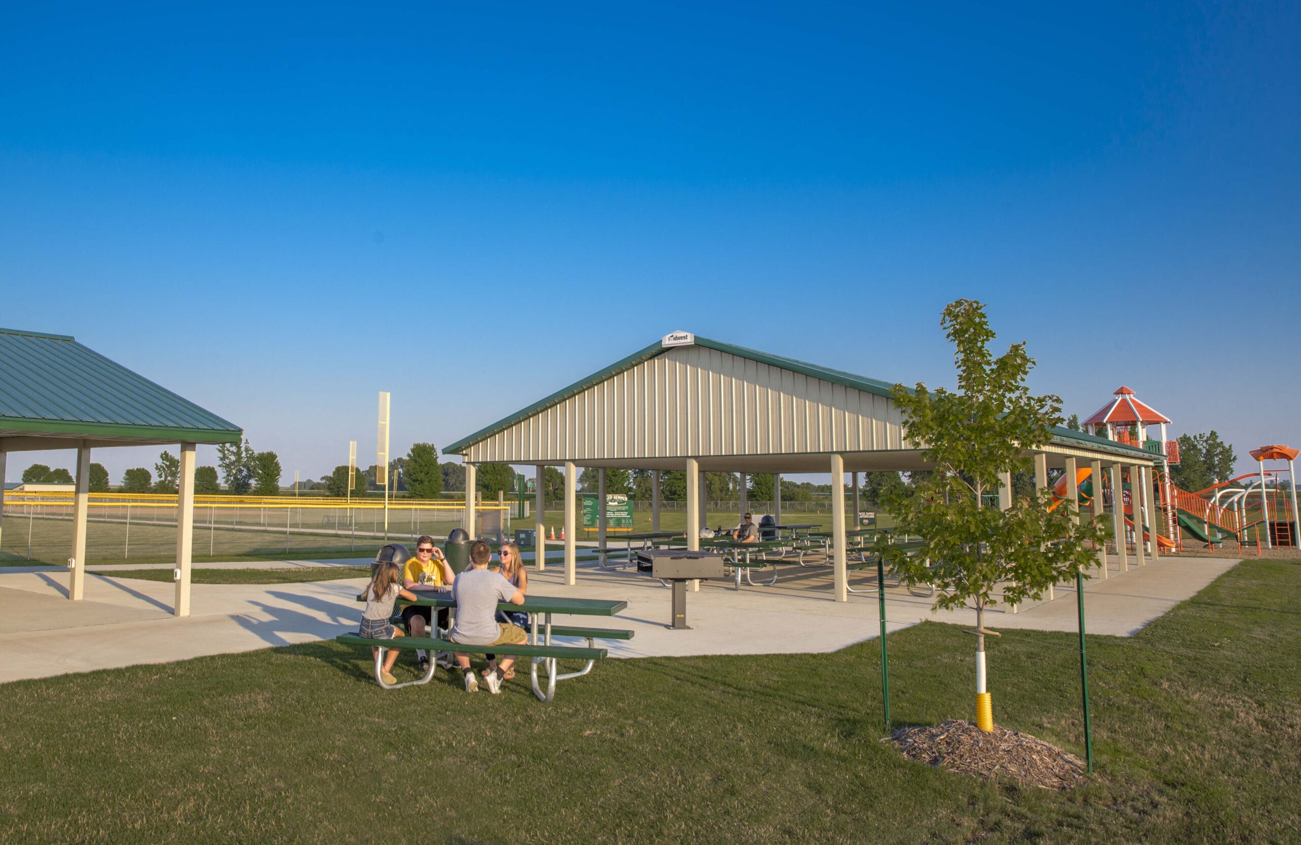 Park picnic area with tables and benches under a covered shelter.