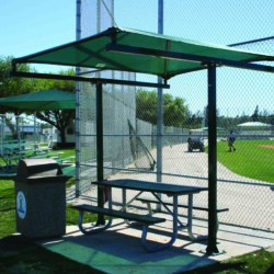 Outdoor picnic shelter with green awning and metal frame.
