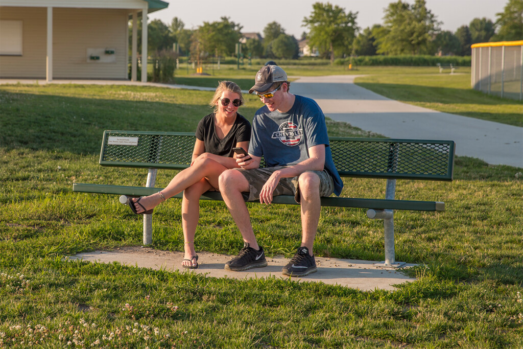 Two people sitting on a park bench.