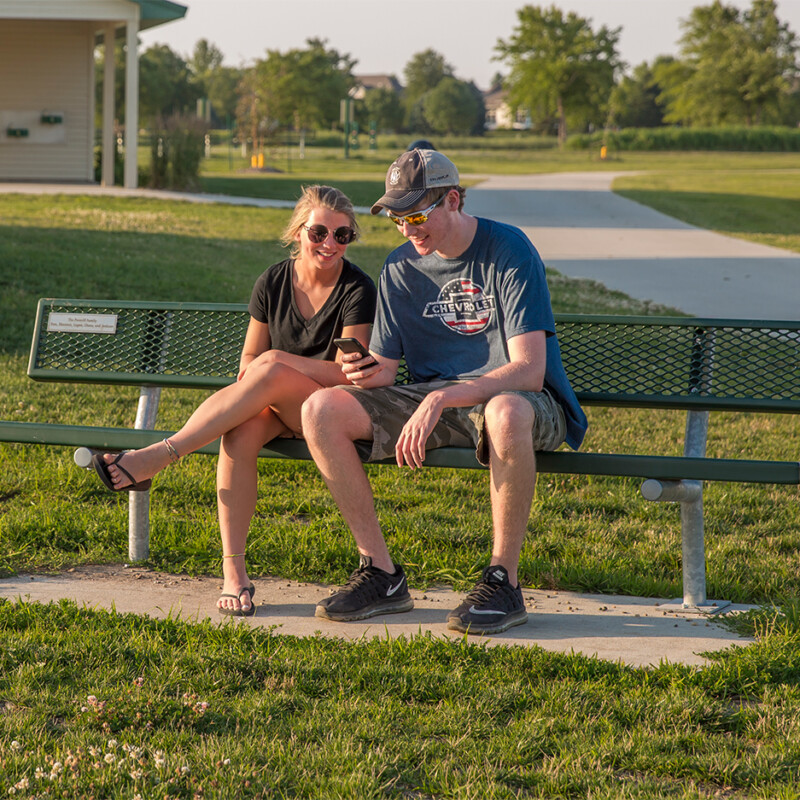Two people sitting on a park bench.