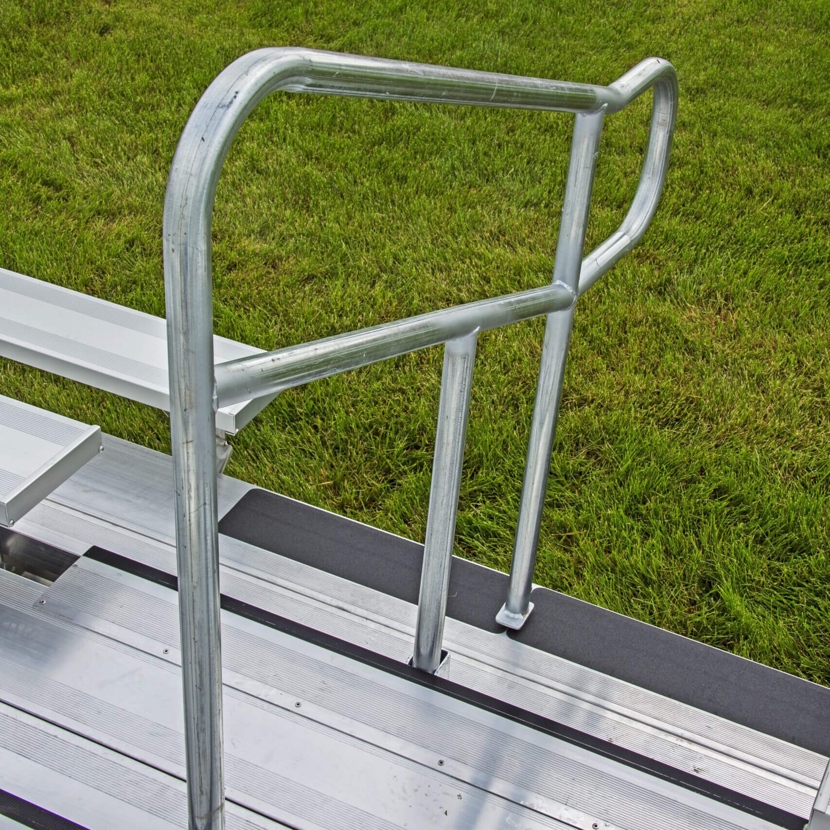 4510F448AHR2WC070R-scaled Metal ladder with handrail on grass.