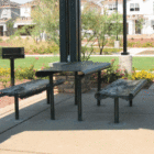 Outdoor picnic table and benches in a park setting.